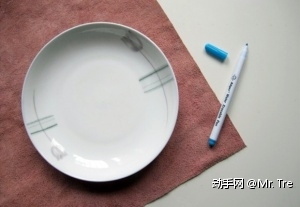 把盘子倒扣在牛皮上（盘子的大小决定包的大小），用笔沿着盘子的边缘来画个圆圈。