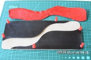教程之一之后续上之二，外层皮的粘接镶嵌和缝合。如图，图钉固定黑色皮几个角，是为了方便将中间红色蛇皮准确粘合固定。中间涂上黄胶。