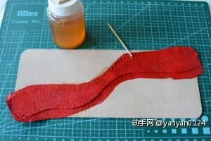 红色蛇皮粘接到中间位置，用牙签压实轮廓。这是为了方便接下来的拉链准确的找准位置粘合。