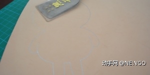根据切下来的图形，用水银笔在皮上描绘出形状。